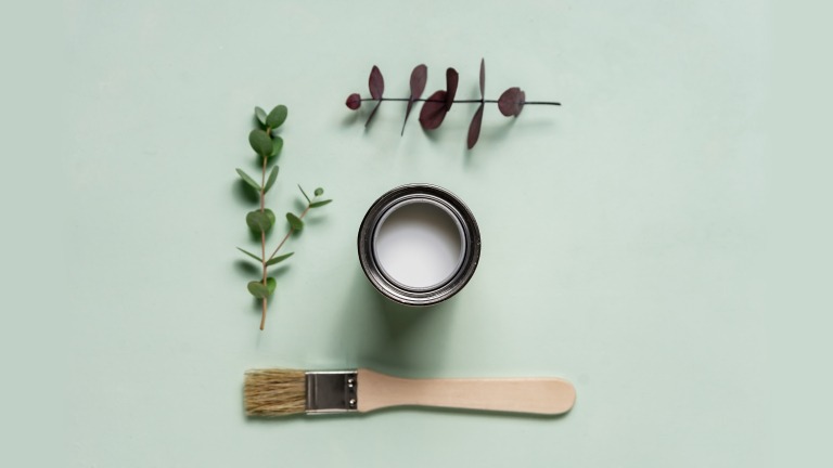 Paint can, paintbrush, and plant branches