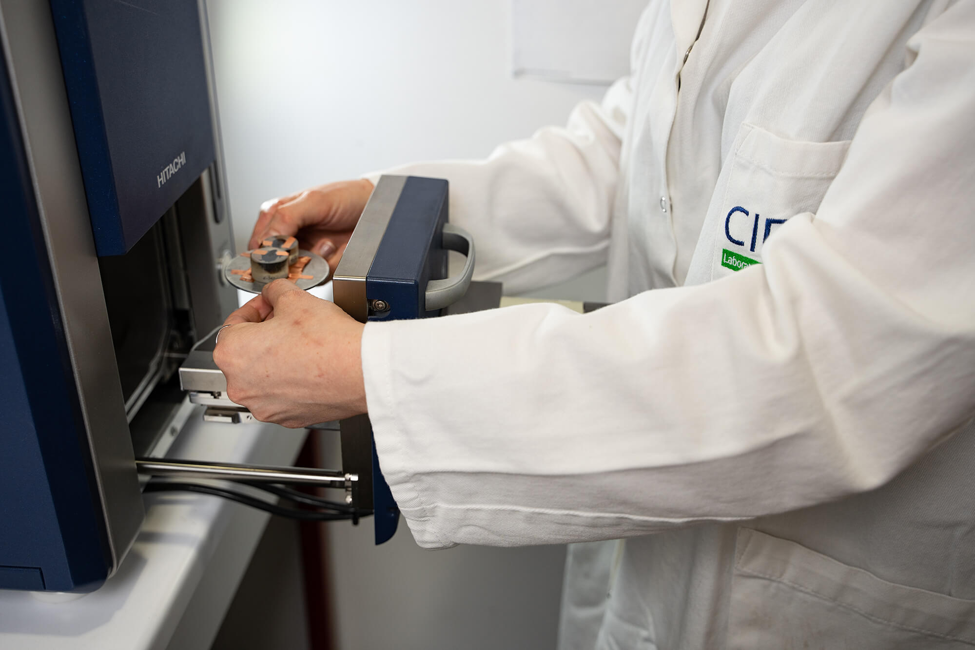 Scientist placing samples in a scanning electron microscope (SEM)