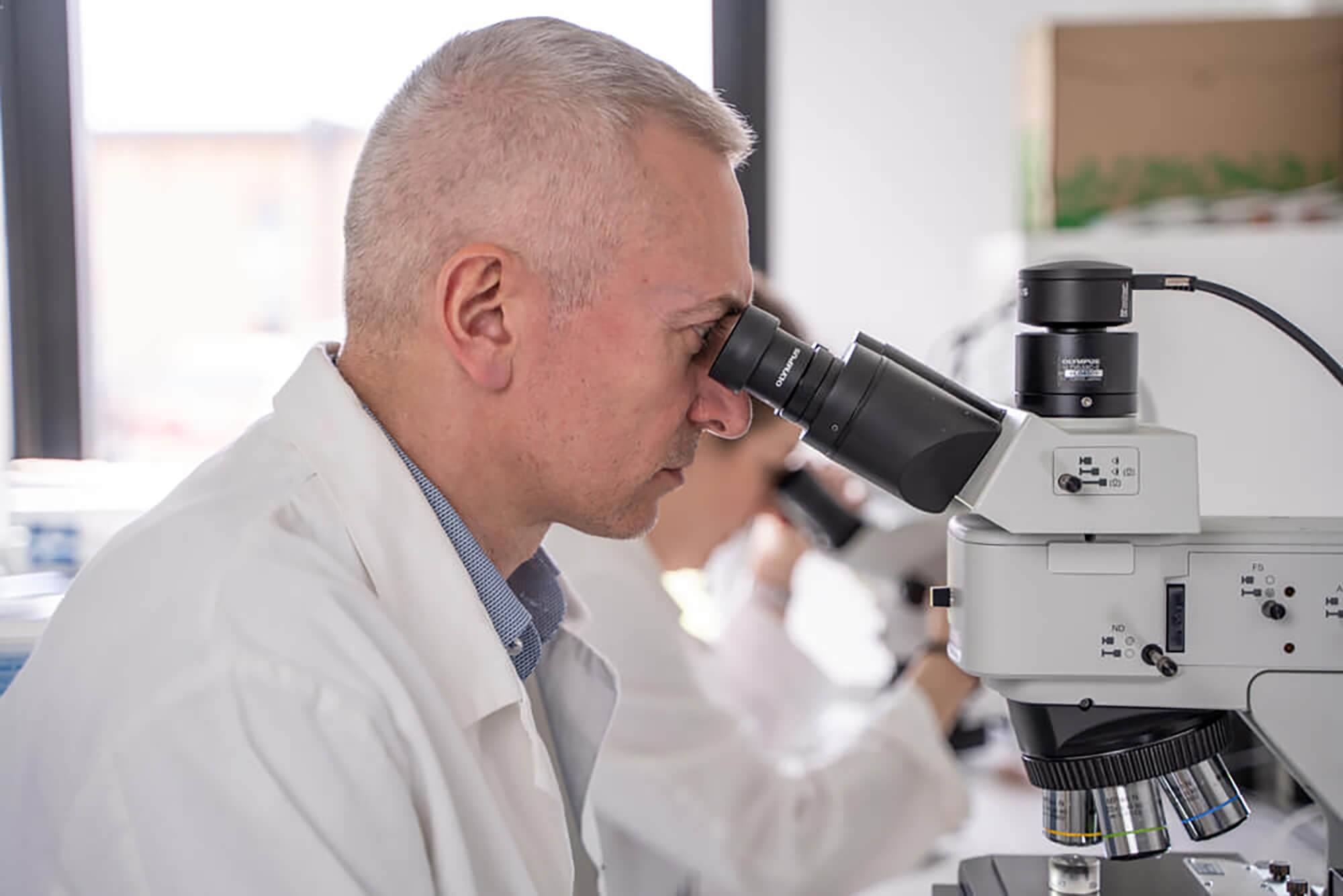 A laboratory scientist analyzing a sample using a scanning electron microscope (SEM)